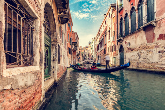 Canal in Venice, Italy with gondolier rowing gondola
