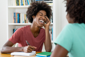 Laughing african american male student preparing for exam on private