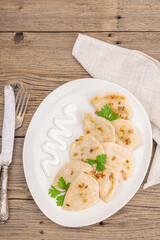 Dumplings, filled with cabbage. Fried onion, fresh sour cream. Traditional Ukrainian dish