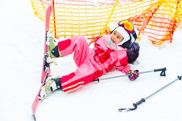 Child skiing in mountains. Active toddler kid with safety helmet, goggles. Winter sport for family.