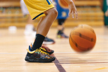 Fototapeta premium Young Boy's Intense Basketball Training on the Court of Champions. School Kids Showcasing Basketball Skills on Training Court. Youth Basketball Player Standing on Court Line and Bouncing Ball