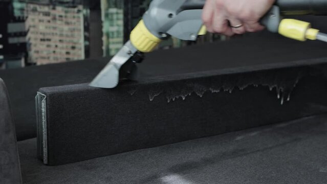 Professional dry cleaning of the sofa with a special chemical solution and a washing vacuum cleaner. Copy space for text