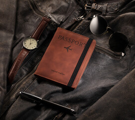 Composition of passport, watch, glasses, wallet, men's accessories, perfume and pen lying on men's jacket. Advertising concept template
