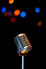 retro microphone on colorful bokeh, music background. singing concept 