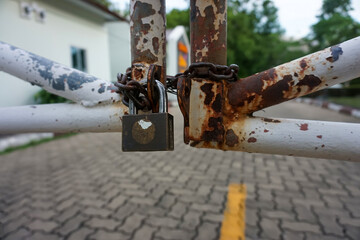Old key lock locked with a chain on a metal door Old