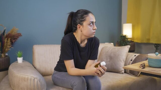 The young woman who looks at the pills in her hand and is going to commit suicide.