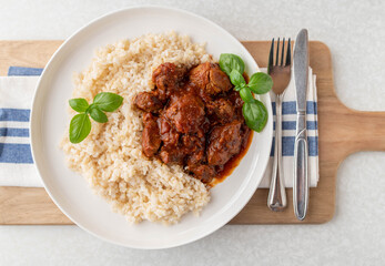 Meat with  brown rice on a plate