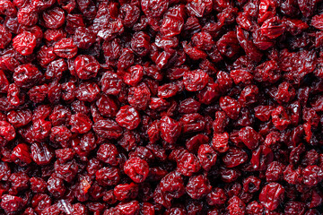 Dry red pitted cherries in the background, closeup, top view. A way to preserve vitamins....