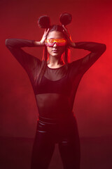 Fototapeta na wymiar Portrait of beautiful cyber model woman posing wearing led glasses on head with neon light in a virtual tech environment