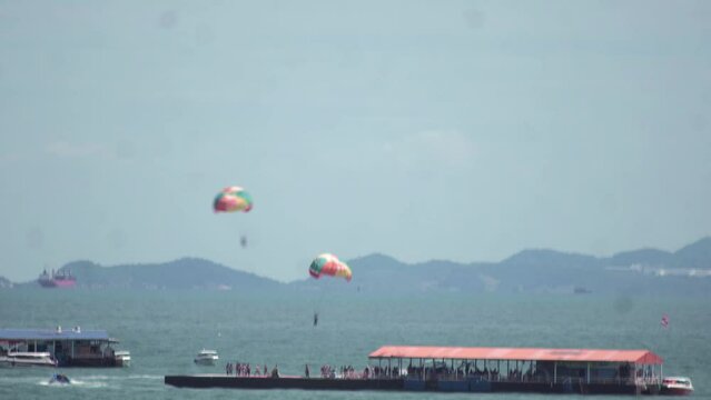 Time-lapse footage of people parasailing above the sea.