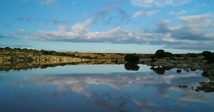 drone shot - flying over a beutiful colorful lake . the clouds are reflected on the water in Golan Heights