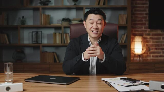 Asian male hr manager greeting new applicant and explaining work responsibilities in modern office. Handsome middle-aged man talking and introducing company to job seeker.