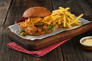 Tasty crispy chicken burger with crispy hamburger buns, cheddar cheese,mayonnaise and french fries