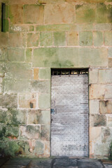 Fototapeta na wymiar Vieille porte cloutée médiévale sur un mur de pierres. Porte en bois ancienne. Bâtiment ancien. Perrecy-les-Forges. 