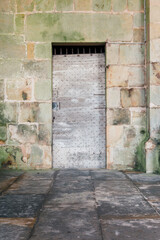 Vieille porte cloutée médiévale sur un mur de pierres. Porte en bois ancienne. Bâtiment ancien. Perrecy-les-Forges. 