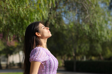 Profile of a relaxed woman in a park breathing