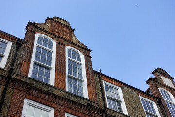 Edwardian style English House with large windows and red bricks in Chelsea, London against blue sky