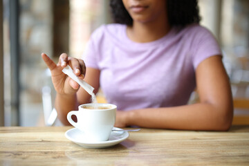Black woman throwing sugar in a coffee cup