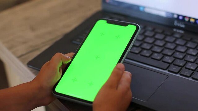 Green screen chroma key kid's hands study online back to school laptop close up