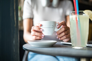 Close up of young woman drinking coffe