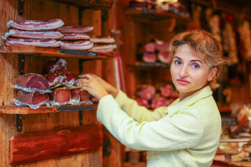 Young woman chooses meat in a market