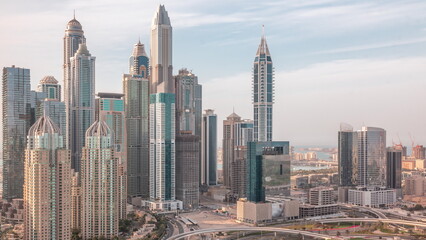 Fototapeta na wymiar Skyscrapers of Dubai Marina near intersection on Sheikh Zayed Road with highest residential buildings all day timelapse