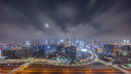 Panoramic skyline of Dubai with business bay and downtown district all night timelapse.