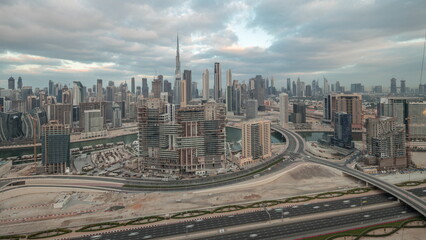 Naklejka na ściany i meble Panoramic skyline of Dubai with business bay and downtown district night to day timelapse.