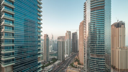 View of the Dubai Marina and JBR area and the famous Ferris Wheel aerial night to day timelapse