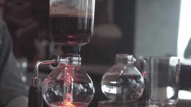 Preparing coffee with syphon at coffee shop.