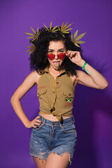 Beautiful rastafarian woman in red sunglasses with marijuana leaves in her hair and on her tongue....