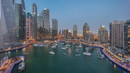 Fototapeta premium Dubai marina tallest skyscrapers and yachts in harbor aerial day to night timelapse.