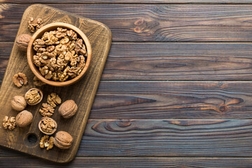 Naklejka na ściany i meble Fresh healthy walnuts in bowl on colored table background. Top view Healthy eating bertholletia concept. Super foods