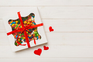 Valentine day composition: sweet candy, with gift boxes with bow and red felt hearts, photo template, background. Top View with copy space