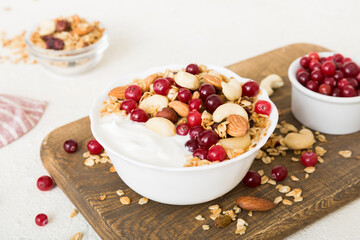 Healthy breakfast food with granola, yogurt, fruits and nuts. Dessert parfait with dried fruits for breakfast