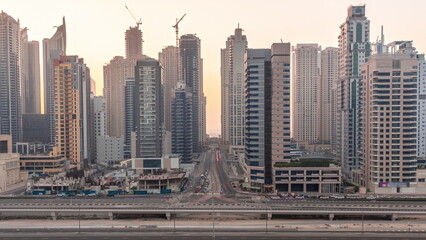 Dubai Marina skyscrapers and Sheikh Zayed road with metro railway aerial all day timelapse, United Arab Emirates