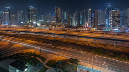 Fototapeta na wymiar Panorama showing Dubai marina tallest block of skyscrapers night timelapse.