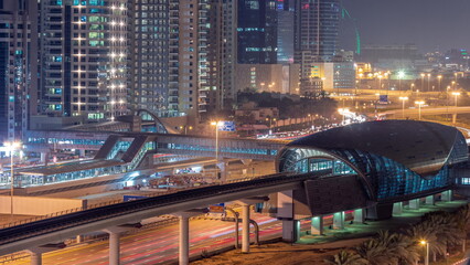 Futuristic building of Dubai metro station and luxury skyscrapers behind in Dubai Marina aerial day to night timelapse