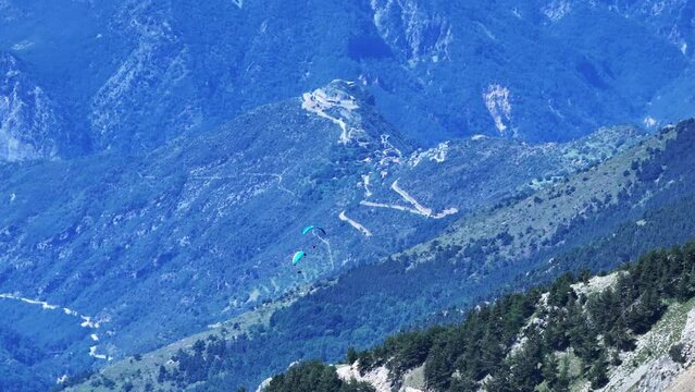 Drone shot of two paragliders floating over Mercantour National Park