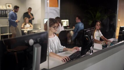 Coworkers looking at a computer and talking about work. Team of colleagues brainstorming together while working on the computer. Men and woman colleagues discuss online project look at pc screen