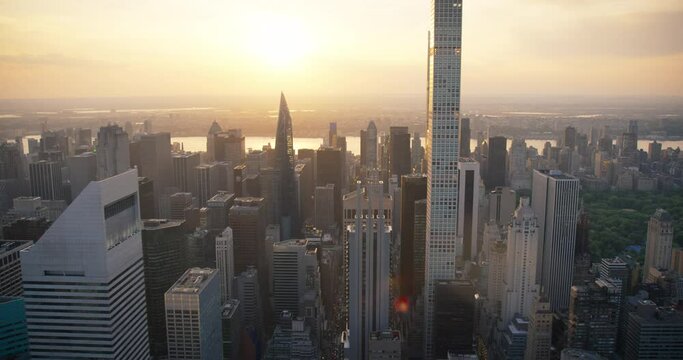 Evening New York City Aerial Landscape with Midtown Manhattan Skyscrapers and Green Nature in Central Park. Cinematic Drone View of Urban Skyline with Scenic Sunset and Light Clouds