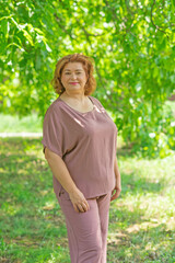 Fototapeta premium Plus size nice lady 50-55 years old dreaming about something positive and smiling. Psychology oа mature people