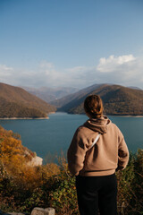 Zhinvali reservoir - river in mountains in Georgia. Girl from back adventure autumn traveling