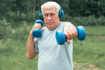 Senior man working out outdoors. Person lifting dumbbells. Old male exercising at park. Healthy people lifestyle. Active sport training. Older elderly sportsman doing fitness exercise. Workout session