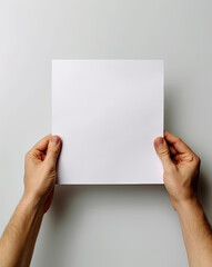 hands are holding a blank sheet of paper with a white background - 624345757