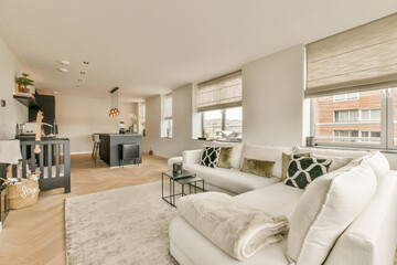 a living room with wood flooring and white couches in the room is decorated with modern decor, including a fireplace