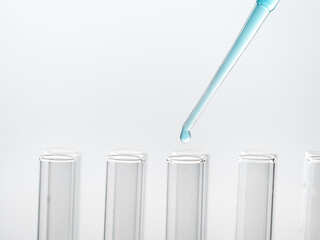 Pipette drip drops into laboratory test glass tubes, nobody