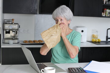 Senior woman suffering a panic attack at home 
