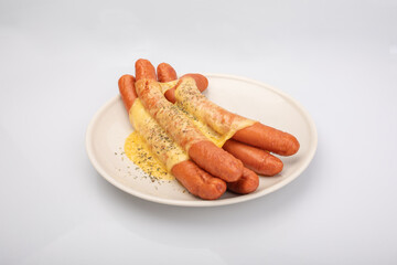 Wiener sausages, frankfurters baked with cheese, on a white plate, isolated on white background. Polish meat product.