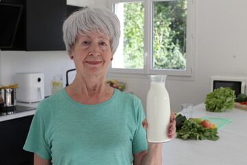 Senior woman showing fresh milk 